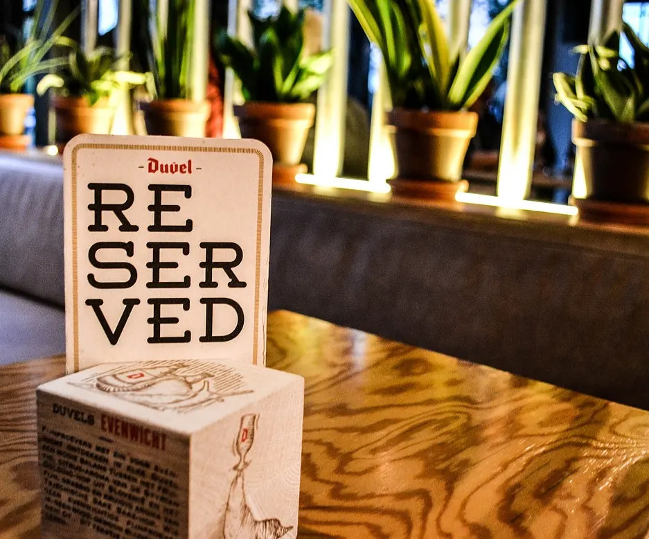 Een bordje ‘Reserved’ op een houten tafel