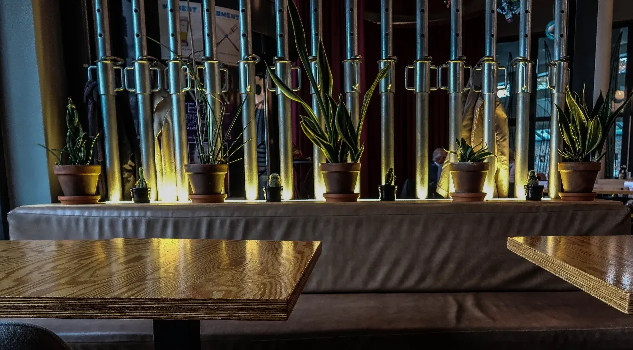 Kruisvormige zitbank met planten in het interieur van Retro Velinx